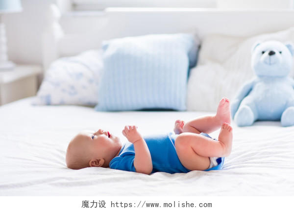 可爱的男婴躺在白色阳光明媚的卧室里
